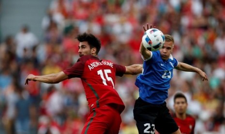 Gelandang Portugal Andre Gomes (kiri) berjibaku melawan pemain Estonia Taijo Teniste.