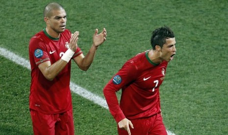  Gelandang Portugal Cristiano Ronaldo diberi aplaus oleh rekannya Pepe (kiri), setelah tampil gemilang dalam pertandingan melawan Belanda di Grup B di Stadion Metalist,Senin (18/6) dini hari WIB.  (Vadim Ghirda/AP)