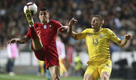 Gelandang Portugal Joao Cancelo (kiri) berebut bola dengan pemain Ukraina Vitaliy Mykolenko dalam laga kualifikasi Piala Eropa 2020. 