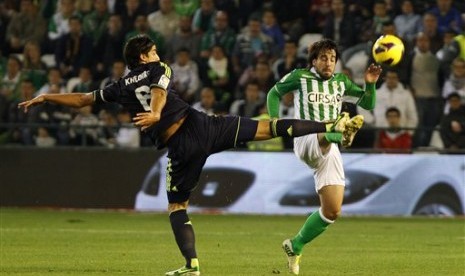 Gelandang Real Betis, Benat Extebarria (kanan) terlihat berebut bola dengan gelandang Real Madrid, Sami Khedira (kiri), pada partai La Liga yang berlangsung di Benito Villamarin Stadium, Ahad (25/11) dini hari. 