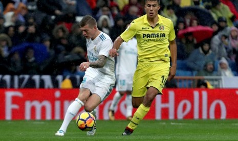 Gelandang Real Madrid Toni Kroos (kiri) berebut bola dengan gelandang Villarreal Rodrigo Hernandez 'Rodri' (kanan) pada lanjutan La Liga di Stadion Santiago Bernabeu, Ahad (14/1) dini hari WIB. 