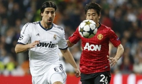 Gelandang Sami Khedira berebut bola dengan Sinji Khagawa.