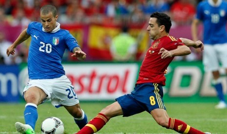 Gelandang Spanyol, Xavi Hernandez dan pemain Italia Sebastian Giovinco berebut bola pada laga pembuka Grup C di Piala Eropa 2012 antara Italia dan Spanyol di Gdansk, Polandia, Ahad (10/6).