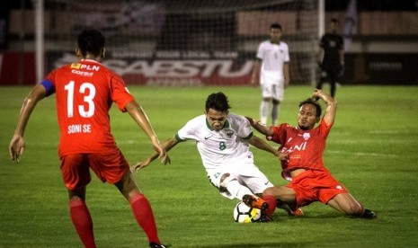 Gelandang tim nasional Indonesia U-19, Witan Sulaiman (tengah), berusaha melewati pemain Persis Solo, Elima Soka, dalam pertandingan uji coba di Stadion Manahan, Solo, Jawa Tengah, Senin (28/5). 