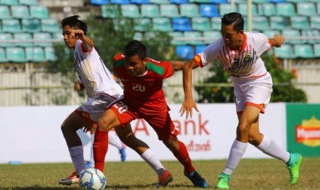 Gelandang timnas Indonesia U-19, Asnawi Mangkualam Bahar (tengah) di antara dua pemain Brunei Darussalam pada laga Piala AFF U-18 di Yangon, Myanmar, Rabu (13/9). Indonesia menang 8-0 pada laga ini.