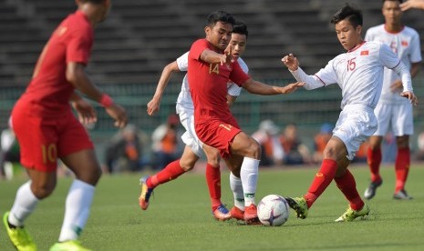 Gelandang timnas Indonesia U-22 Asnawi Mangkualam (tengah) berebut bola dengan pemain Vietnam U-22 pada semifinal Piala AFF U-22, Ahad (24/2).