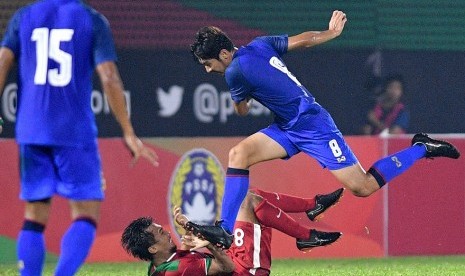 Gelandang timnas Indonesia U-23 Muhammad Hargianto (bawah) terjatuh saat berebut bola dengan pemain Thailand U-23 Ratchanat Arunyapairot (kanan) dalam pertandingan persahabatan di Stadion PTIK, Jakarta, Kamis (31/5) malam. Indonesia kalah 1-2 dari Thailand. 