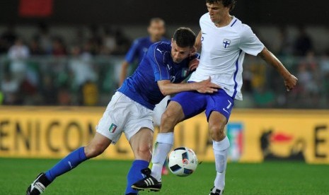 Gelandang timnas Italia Thiago Motta (kiri) berebut bola dengan gelandang Finlandia Roman Eremenko. 