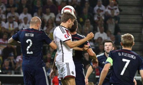 Gelandang Timnas Jerman, Thomas Mueller (dua kiri), melepaskan sundulan menjebol gawang Skotlandia dalam laga pembuka grup Piala Eropa 2016 di Dortmund, Jerman, Ahad (7/9). 