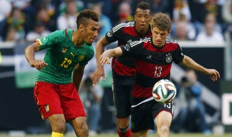 Gelandang timnas Jerman, Thomas Mueller (kanan), berebut bola dengan pemain Kamerun, Eric Choupo-Moting (kiri), dalam laga internasional di Moenchengladbach pada Ahad (1/6). 