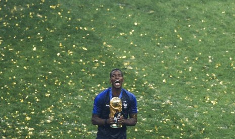 Gelandang timnas Prancis, Paul Pogba, bersama trofi Piala Dunia. Prancis mengalahkan Kroasia 4-2 pada laga final di Moskow, Ahad (14/7).