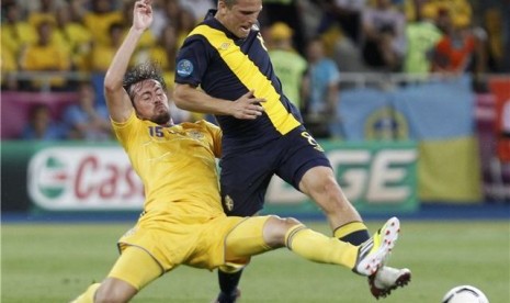 Gelandang timnas Swedia, Anders Svensson (kanan), bertarung dengan pemain Ukraina, Artem Milevskiy, di laga perdana Grup D Piala Eropa 2012 di Kiev, Ukraina, pada Senin (11/6). 