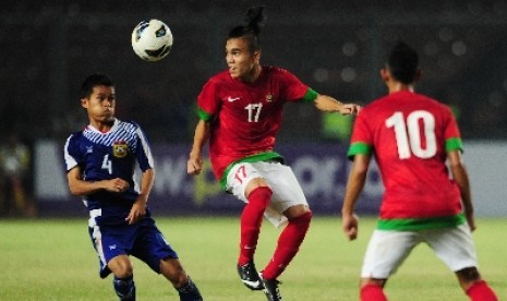 Gelandang timnas U-19 Indonesia, Paulo Sitanggang (tengah), berebut bola saat laga grup G kualifikasi Piala Asia (AFC) U-19 melawan Laos di Stadion Gelora Bung Karno, Senayan, Jakarta, Selasa (8/10) malam. 