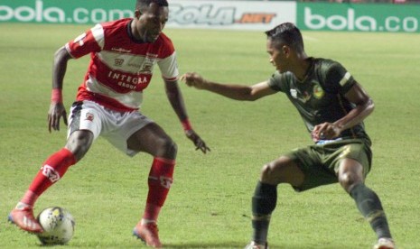 Gelandang Tira Persikabo Abduh Lestaluhu (kanan) berusaha merebut bola dari gelandang Madura United Engelberd Sani (kiri) pada laga Liga 1 2019 di Stadion Pakansari, Bogor, Jawa Barat, Jumat (12/7).