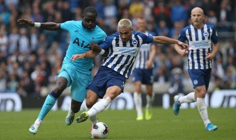 Gelandang Tottenham Hotspur Moussa Sissoko (kiri) berebut bola dengan penyerang Brighton Neal Maupay.