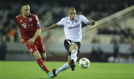 Gelandang Valencia, Sofiane Feghouli, dibayang-bayangi winger Bayern Muenchen, Franck Ribery, pada laga yang berlangsung di Mestalla, Valencia, Rabu (21/11) dini hari. Kedua tim bermain imbang 1-1 dan sama-sama memastikan satu tempat di fase knock-out.