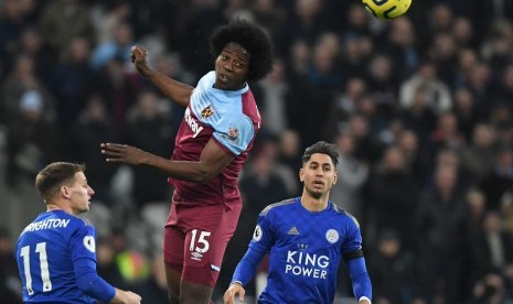 Gelandang West Ham, Carlos Sanchez (tengah) menyundul bola di antara dua pemain Leicester City pada laga Liga Primer Inggris, di Stadion King Power, Ahad (29/12) dini hari WIB. Leicester menang 2-1.