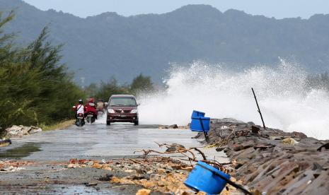 Gelombang tinggi melewati tanggul pemecah ombak di pesisir pantai (ilustrasi)