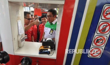 General Manager Pertamina MOR IV, Yanuar Budi Hartanto mencoba keandalan proses transaksi non tunai di SPBU dengan T-cash, di SPBU 44.501.40 Jalan Jendral Sudirman Semarang, Rabu (13/12). 