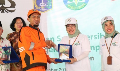 General Manager PLN Pusenlis Chairani Rachmatullah (berkaca mata) memberikan plakat kepada warga Kelurahan Kota Bambu Selatan, Kecamatan Palmerah, Jakarta Barat, Kamis (3/10/2019), sebagai simbol dimulainya Gerakan Sadar Bersih