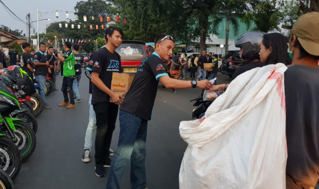 Klub penggemar motor yang tergabung dalam komunitas Kawasaki Ninja Indonesia (KNI) chapter Purwakarta, membagikan takjil gratis bagi pengendara yang melintasi Lapang Sahate, Jl KK Singawinata, Purwakarta, Kamis (30/5). 