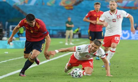 Gerard Moreno (kiri) dari Spanyol beraksi melawan Jan Bednarek (tengah) dari Polandia dalam pertandingan Euro 2020.