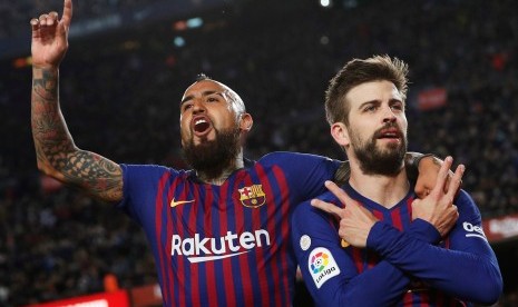 Gerard Pique (kanan) merayakan gol bersama rekan setimnya Arturo Vidal pada laga Barcelona versus Rayo Vallecano di Stadion Camp Nou, Barcelona, Katalunya, Spanyol, Sabtu (9/3) waktu setempat.