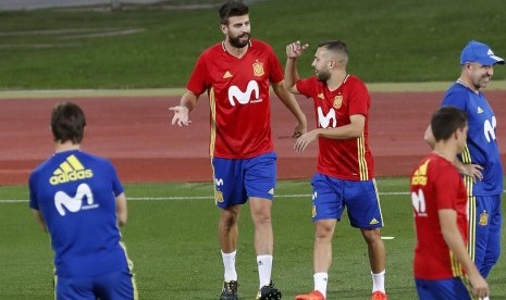 Gerard Pique (kedua kiri) bercengkrama dengan Jordi Alba dalam latihan timnas Spanyol di Las Rozas, Madrid, Senin (2/10).