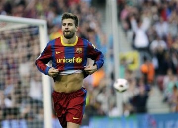 Gerard Pique merayakan gol yang ia cetak ketika timnya bertanding melawan Espanyol, Senin (9/5) dini hari WIB.