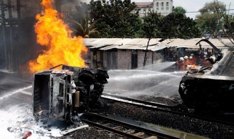 Gerbong penumpang Kereta Rel Listrik Commuterline jurusan Serpong-Jakarta terguling setelah menabrak mobil tangki di perlintasan kereta di Bintaro Permai, Tangerang, Senin (9/12).