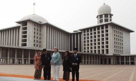 German Chancellor Angela Merkel (center) stands as she pose for a photograph with Indonesian Trade Minister Mari Elka Pangestu (left) and mosque officials during her visit to Istiqlal Mosque in Jakarta July 10, 2012.   Reuters/Beawiharta