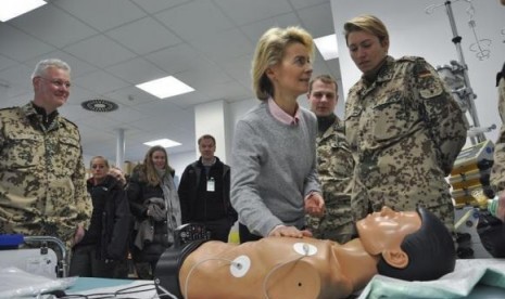 German Defence Minister Ursula von der Leyen (center) takes part in a medical training for CPR (cardiopulmonary resuscitation) on a dummy as she visits the field hospital at the ISAF camp in Mazar-i-Sharif, December 23, 2013.