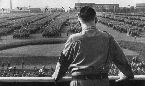 German Fuhrer and Nazi leader Adolf Hitler (1889 - 1945) addresses soldiers with his back facing the camera at a Nazi rally in Dortmund, Germany. 