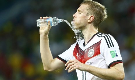 Germany's Per Mertesacker refreshes himself after the 2014 World Cup Group G soccer match between Germany and Ghana at the Castelao arena in Fortaleza June 21, 2014.