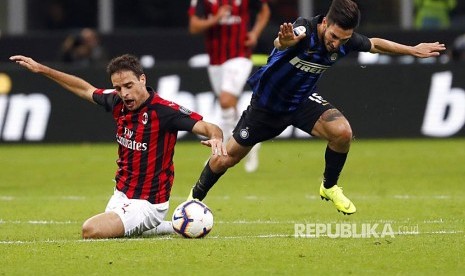 Giacomo Bonaventura (kiri) dan Matteo Politano (kanan) berebut bola pada laga derby antara Inter Milan dan AC Milan di Stadion San Siro, Milan, Senin (22/10) dini hari.