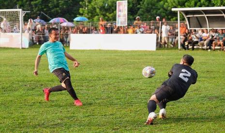 Gibran Rakabuming Raka berupaya mengegolkan bola dari gawang yang dijaga Raffi Ahmad. Cawapres Gibran bertanding sepakbola lawan Raffi Ahmad dalam acara Samsul Mini Soccer.