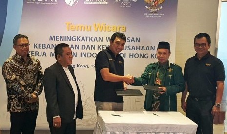 GM BNI Hong Kong Wan Andi Aryadi (tengah) dan Ketua Tanfidziah Pengurus Cabang Istimewa NU Hong Kong Kistiawanto (kedua kanan) berjabat tangan usai penandatanganan Perjanjian Kerja Sama Peluncuran Kartu Tanda Anggota Nahdlatul Ulama (KARTANU) Hong Kong di Hong Kong, Ahad (12/1). Turut menyaksikan Konjen RI di Hong Kong Ricky Suhendar (kiri), Ketua Dewan Pembina Santri Millenial Center NU (SiMaC) Ahmad Syauqi (kedua kiri), dan Pemimpin Divisi Internasional BNI Eko Setyo Nugroho (kanan).