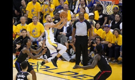 Guard Golden State Warriors Stephen Curry mencetak angka saat melawan LA Clippers pada gim kedua play-off NBA di Oracle Arena di Oakland, Kalifornia, AS, Selasa (16/4).