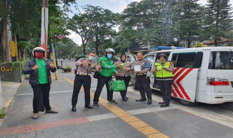 Grab bagikan 1000 paket makanan dan minuman bagi tenaga medis dan kepolisian di Bandung dan sekitarnya, Selasa (31/3).