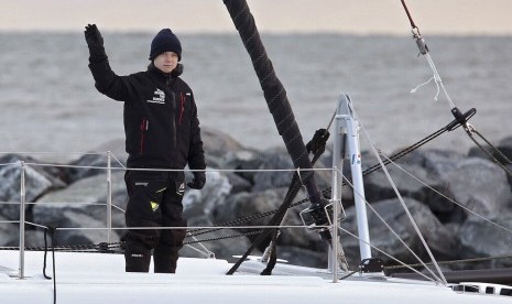 Greta Thunberg melambaikan tangannya di atas kapal katamaran La Vagabonde saat berlayar keluar dari Salt Ponds di Hampton, Virginia, Amerika, Rabu (13/11).