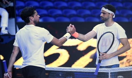 Grigor Dimitrov dari Buglaria (kanan) berjabat tangan dengan Dominic Thiem dari Austria setelah Dimitrov memenangkan pertandingan putaran keempat di kejuaraan tenis Grand Slam Australia Terbuka di Melbourne, Australia, Ahad, 14 Februari 2021. 