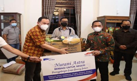 Menteri Koordinator Bidang Politik, Hukum, dan Keamanan Republik Indonesia Mahfud MD (tengah) menyaksikan penyerahan bantuan untuk korban bencana alam erupsi Gunung Semeru dari Astra yang diwakili oleh Chief of Corporate Affairs Astra Riza Deliansyah (kiri) kepada Bupati Lumajang Thoriqul Haq (kanan) pada hari ini (17/12) yang berlokasi di pendopo Kabupaten Lumajang.