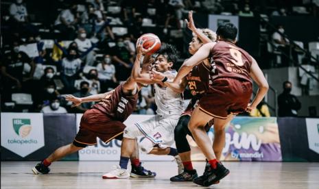 Guard Amartha Hangtuah Fisyaiful Amir (membala bola) dijaga tiga pemain Bima Perkasa Jogja dalam pertandingan Seri 1 IBL 2022 di Jakarta, Selasa (18/1/2022).