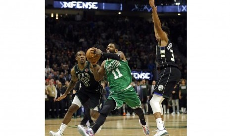 Guard Boston Celtics Kyrie Irving membawa bola.