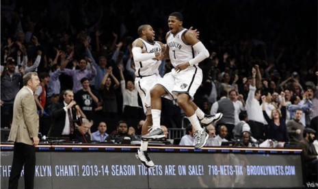 Guard Brooklyn Nets, Joe Johnson (kanan), bersama rekannya guards C.J. Watson meloncat gembir setelah tembakannya di detik terakhir membawa Nets menang tipis 113-111 dari Milwaukee Bucks pada laga NBA di Barclays Center, New York, Selasa (19/2). 