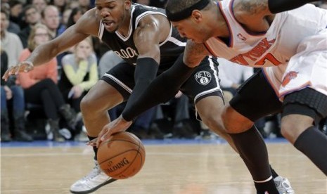 Guard Brooklyn Nets, Joe Johnson (kiri), berusaha mencuri bola dari pemain lawan dalam sebuah laga NBA. 