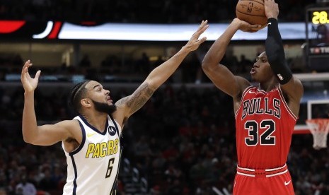 Guard Chicago Bulls, Kris Dunn (kanan), melemparkan tembakan saat menghadapi guard Indiana Pacers, Cory Joseph, dalam pertandingan basket NBA di Chicago, Amerika Serikat, Jumat (4/1). 