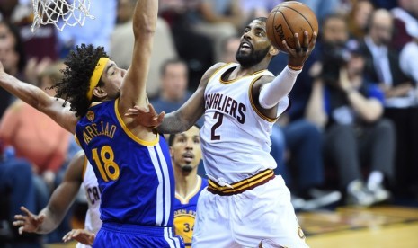 Guard Cleveland Cavaliers Kyrie Irving (kanan) melakukan lay up dijaga pemain Golden State Warriors pada gim ketiga final NBA 2016.