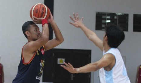 Guard CNN Indonesia Erlangga Wisnuaji mencoba melepaskan tembakan dijaga small forward Jurnalis All Stars Rizky Khaufan.