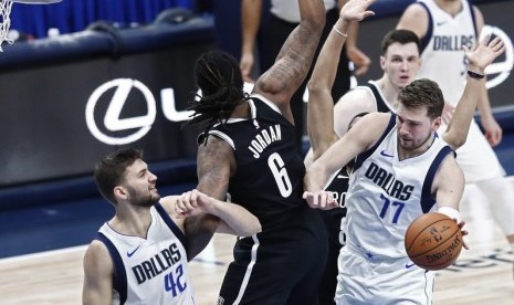 Guard Dallas Maverick Luka Doncic (kanan) dihalangi oleh dua pemain Brooklyn Nets untuk melepas operan atau menembak ke ring dalam pertandingan NBA, Jumat (3/1) WIB. 